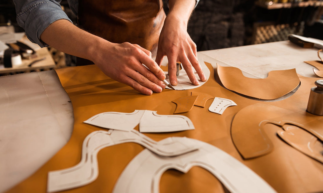 Artisan drawing product sketches and working with leather in HappyPatina workshop