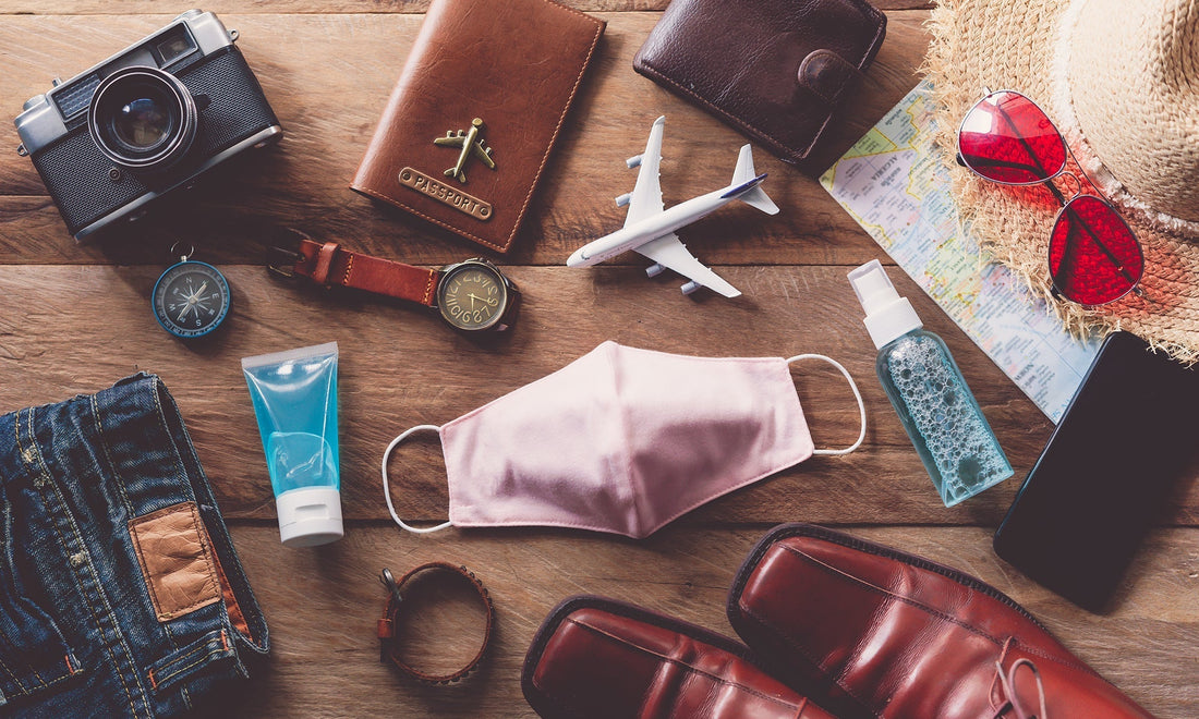 Leather travel accessories neatly arranged with passport and camera on linen surface by HappyPatina