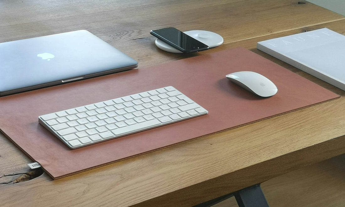 Organized Apple workspace with leather desk pad, MacBook, and accessories by HappyPatina