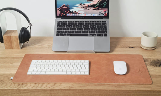 Minimal wooden desk with natural leather desk pad and HappyPatina accessories in soft daylight