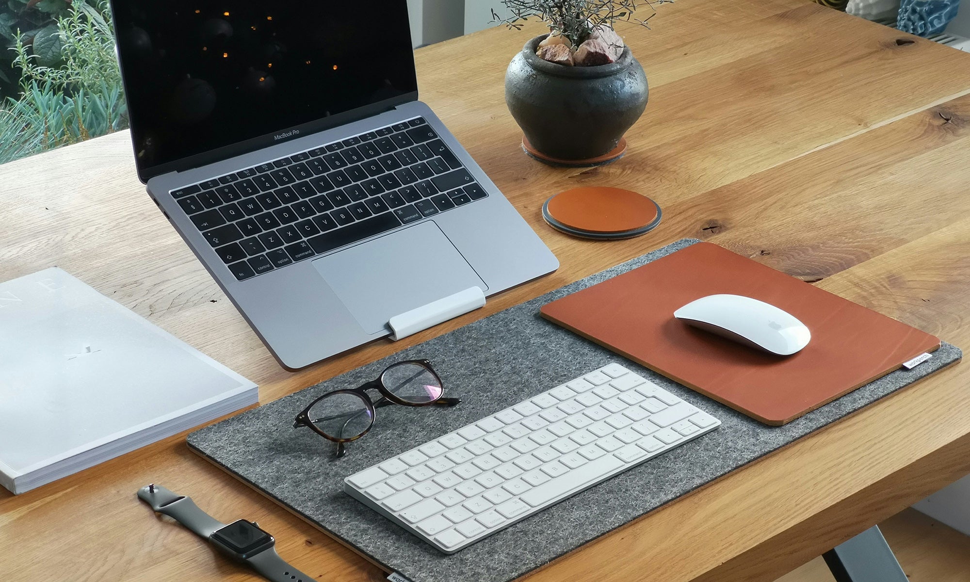 Apple devices on leather desk pad in warm natural light — HappyPatina.