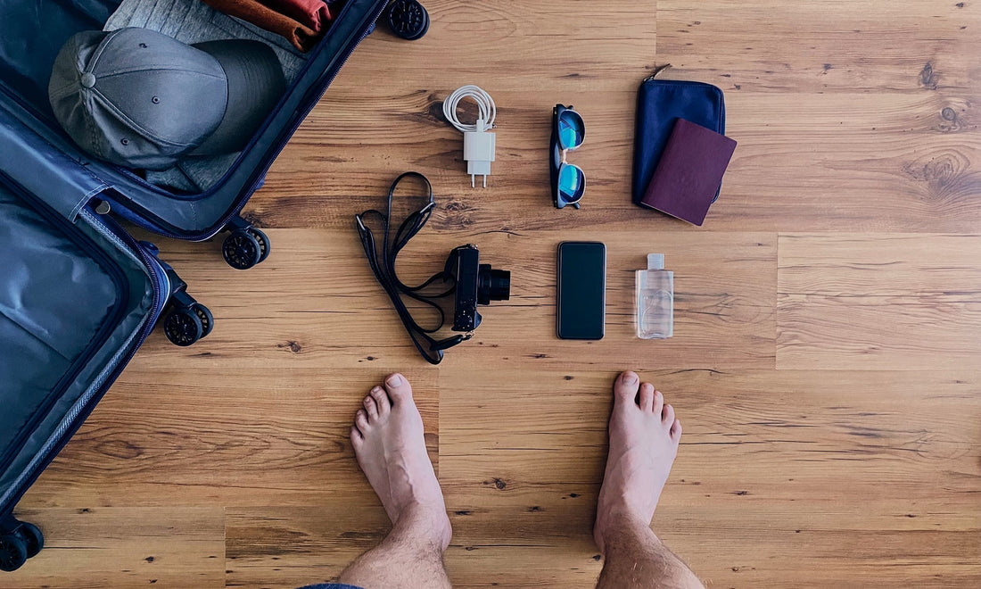 Minimal leather travel essentials packed lightly in soft light by HappyPatina