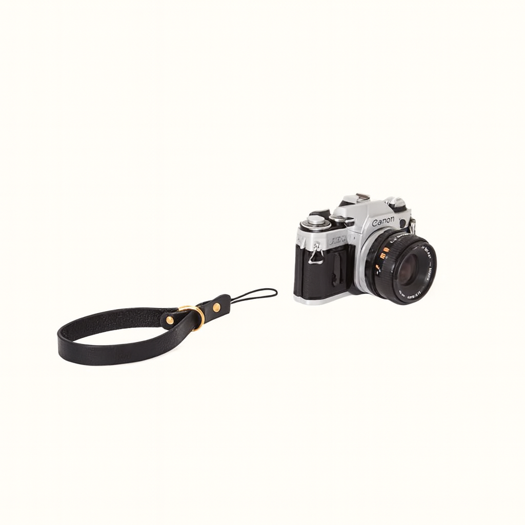 Handcrafted natural veg-tan black leather camera wrist strap with brass hardware by Happy Patina